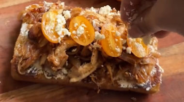 Caramelised onion chicken toast topped with cream cheese, cherry tomatoes, and feta